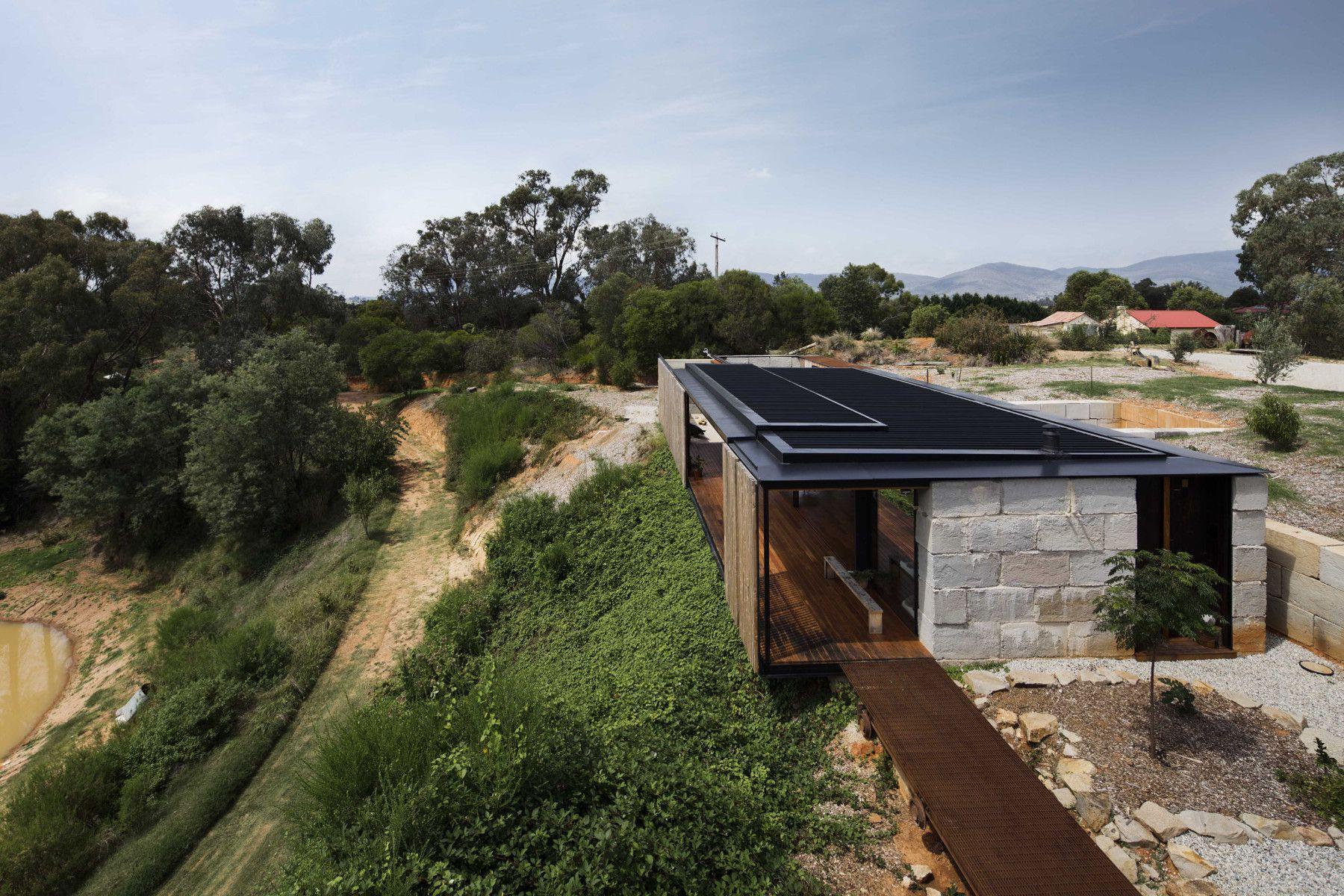 The Sawmill House uses large reclaimed one tonne blocks of reclaimed concrete which anchor it into the landscape and a ...